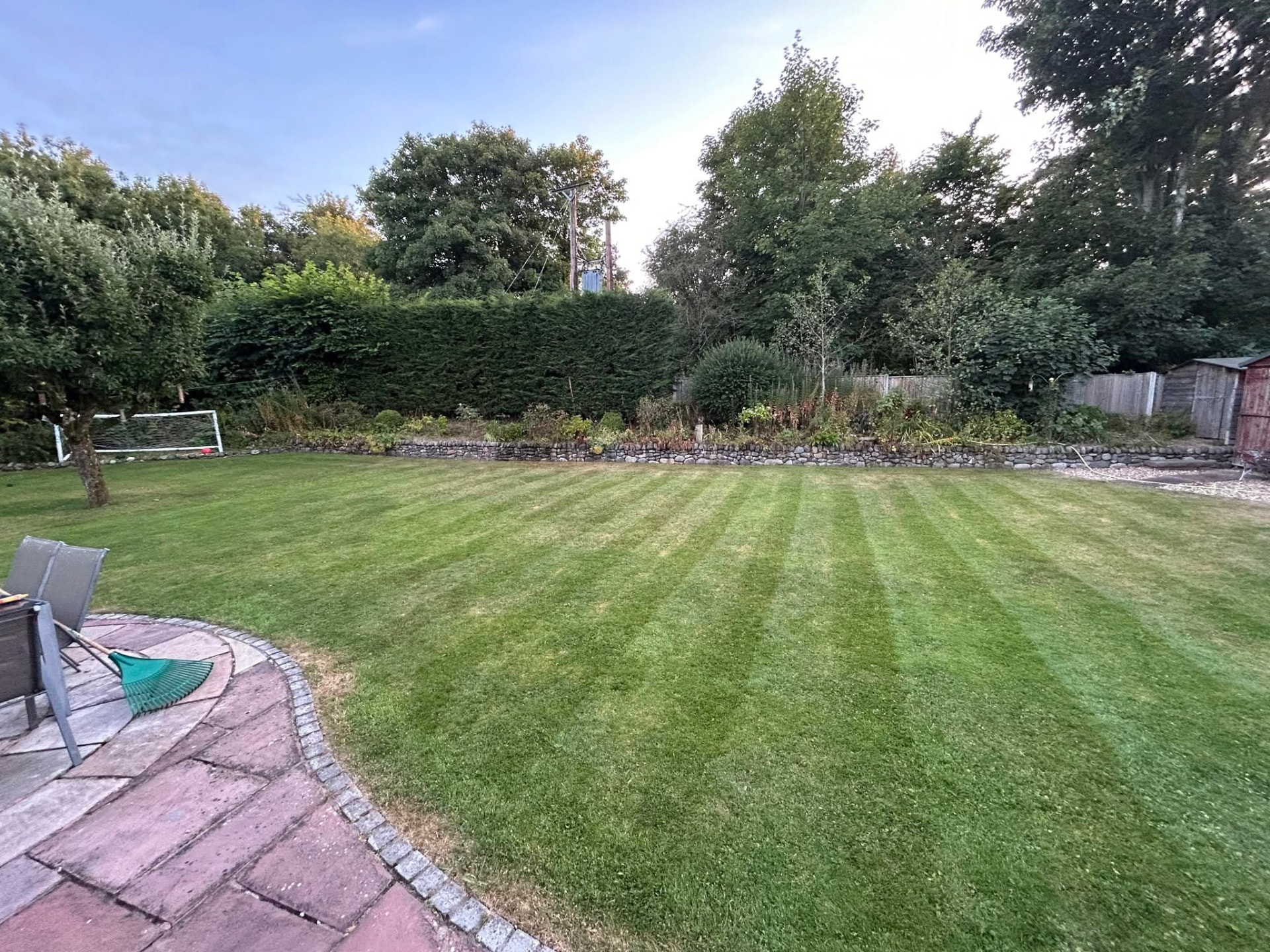 A neatly mown lawn maintained by Cumbria Gardens